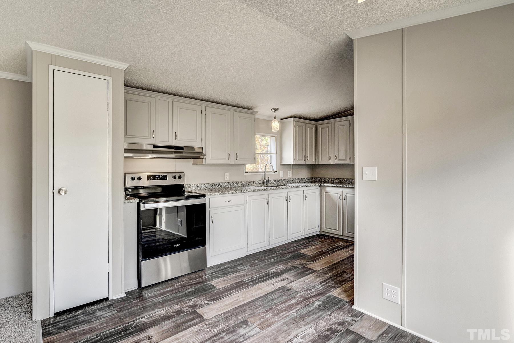 4920 Zacks Mill Road Angier, NC 27501 - Photo 11 of 30 a kitchen with granite countertop white cabinets and appliances