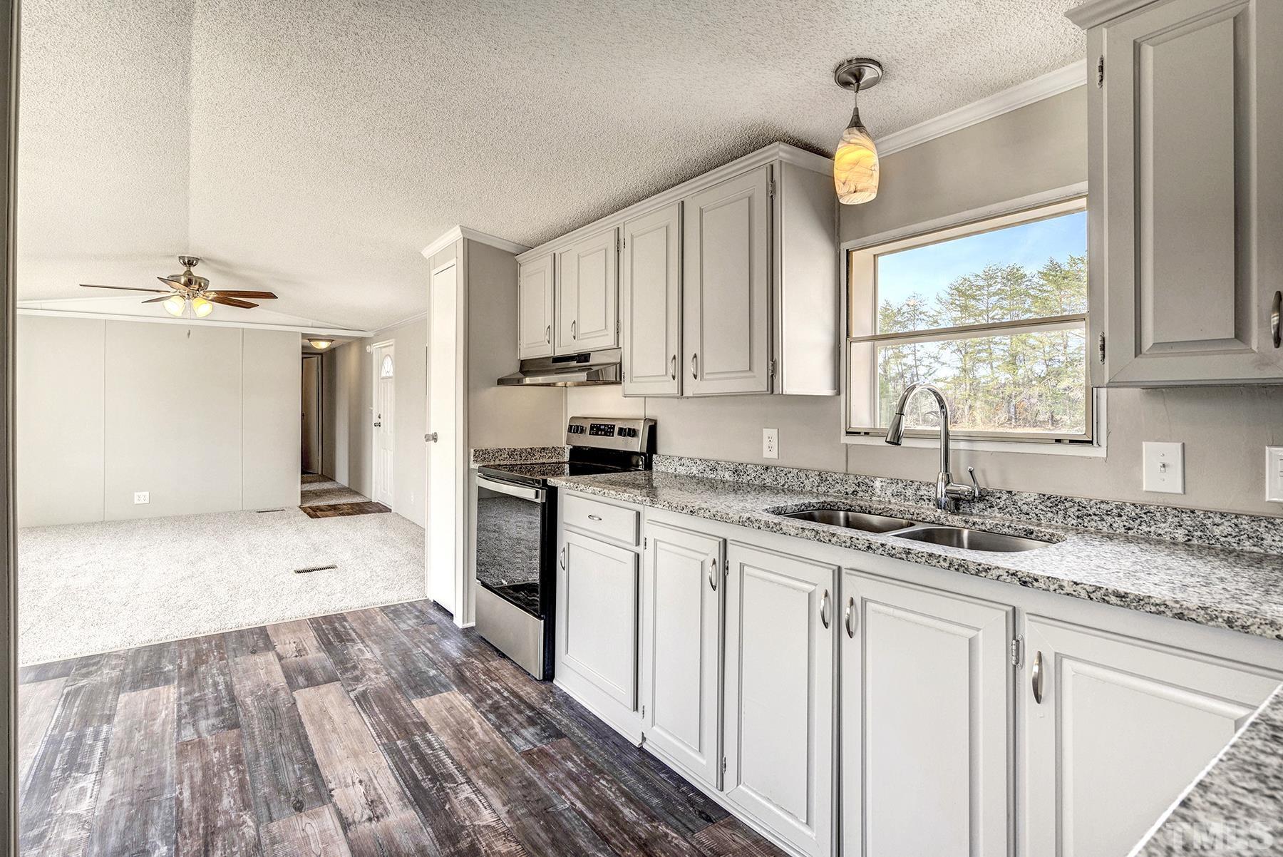 4920 Zacks Mill Road Angier, NC 27501 - Photo 14 of 30 a kitchen with granite countertop a sink cabinets stainless steel appliances and a window