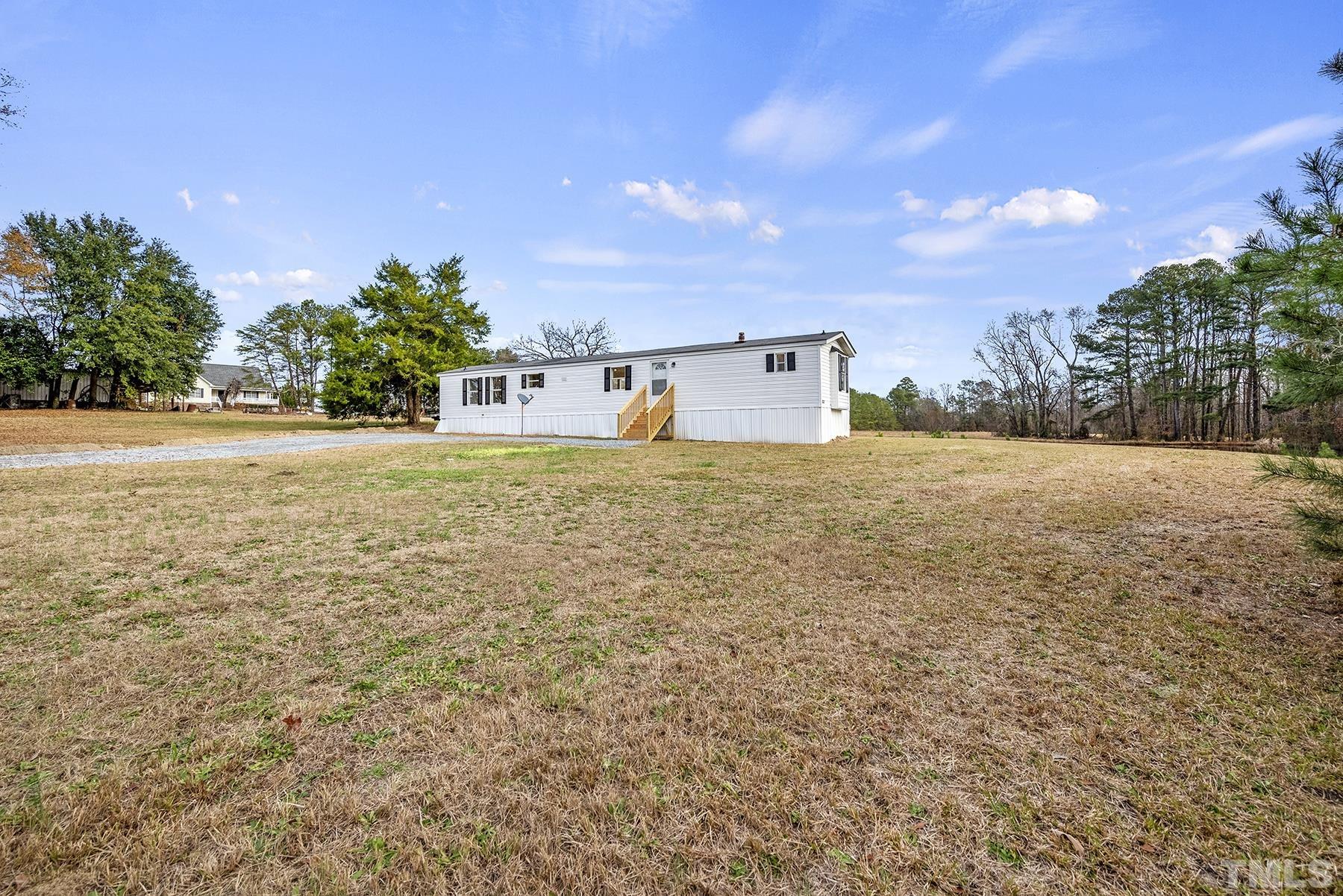 4920 Zacks Mill Road Angier, NC 27501 - Photo 3 of 30 a backyard of a house with lots of green space and plants