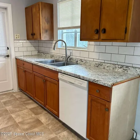 a kitchen with granite countertop a sink and cabinets