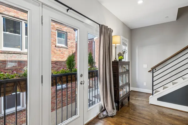 a view of a bedroom with wooden floor and windows