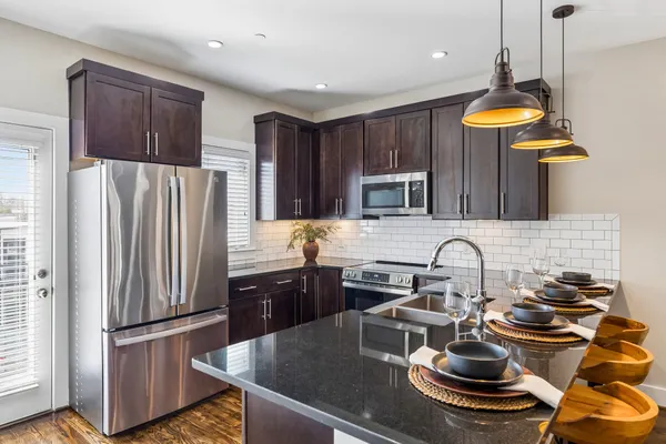 a kitchen with stainless steel appliances granite countertop a sink stove and refrigerator