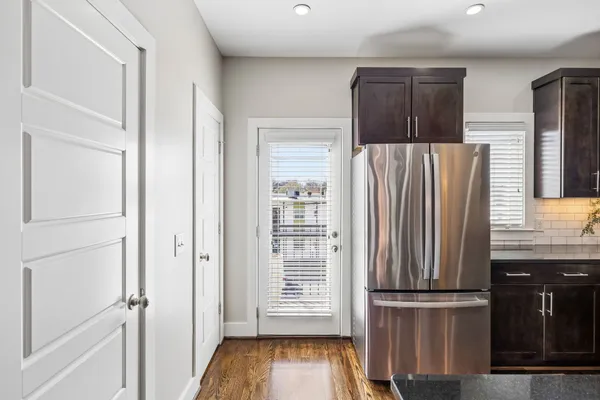 a view of kitchen with wooden cabinets and refrigerator