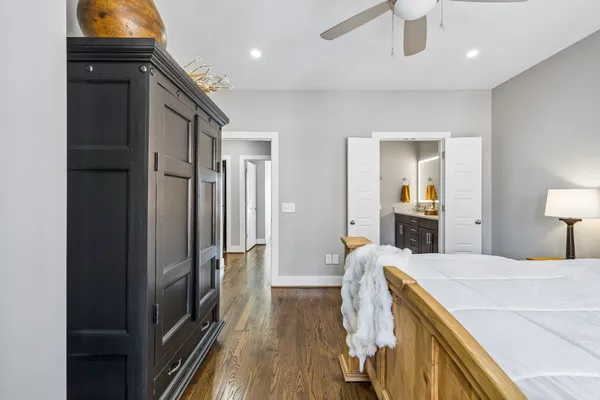 a bedroom with a bed and a lamp on dresser