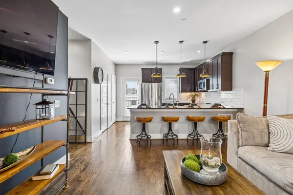 a living room with stainless steel appliances kitchen island granite countertop furniture and a kitchen view