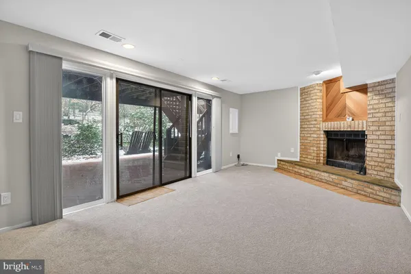 a view of empty room with floor to ceiling window and fireplace