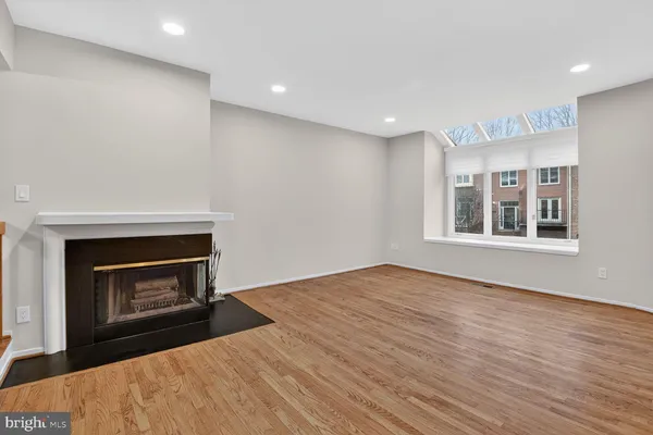 a view of an empty room with a fireplace and a window