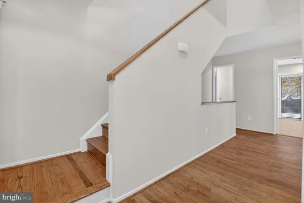 a view of hallway with wooden floor and stairs