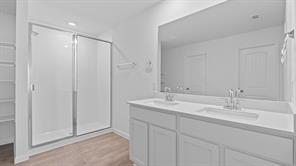 119 Morning Glory Loop Kyle, TX 78640 - Photo 12 of 24 Bathroom with double vanity, a stall shower, and light wood-type flooring