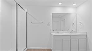 119 Morning Glory Loop Kyle, TX 78640 - Photo 14 of 24 Bathroom featuring double vanity, a stall shower, and light wood-style flooring