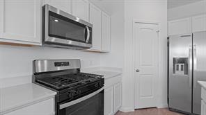 119 Morning Glory Loop Kyle, TX 78640 - Photo 4 of 24 Kitchen with stainless steel appliances, light countertops, and white cabinets