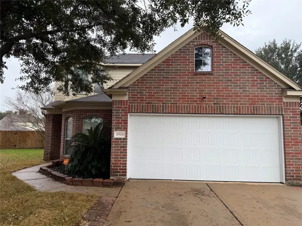 a view of a house with backyard and trees