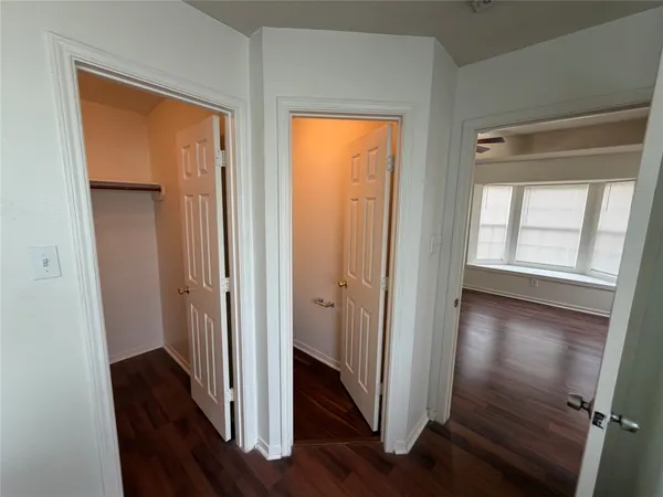 a view of a hallway with wooden floor and a window