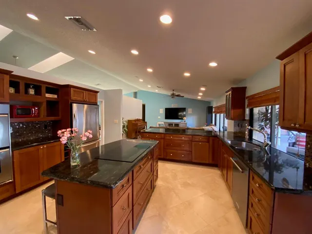 a large kitchen with stainless steel appliances and a large counter top