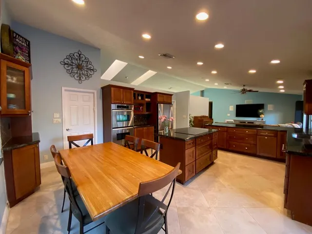 a large kitchen with kitchen island a sink table and chairs
