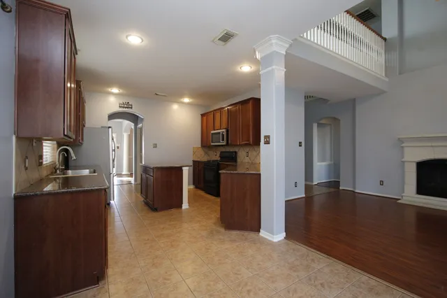 a view of a kitchen with refrigerator and a sink