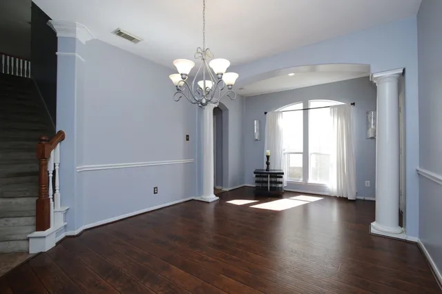 a view of a livingroom with wooden floor and a ceiling fan