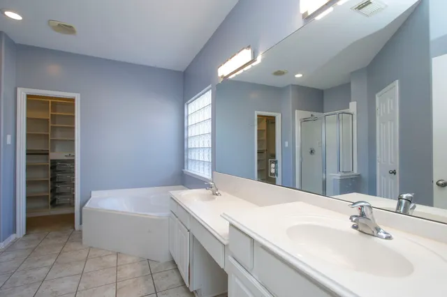 a spacious bathroom with a bathtub sink and mirror