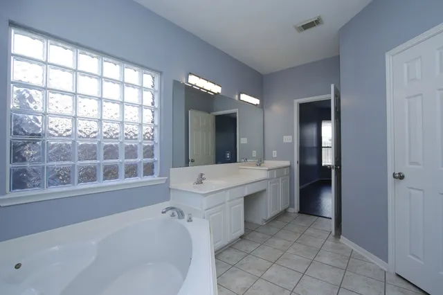 a bathroom with a tub sink and mirror