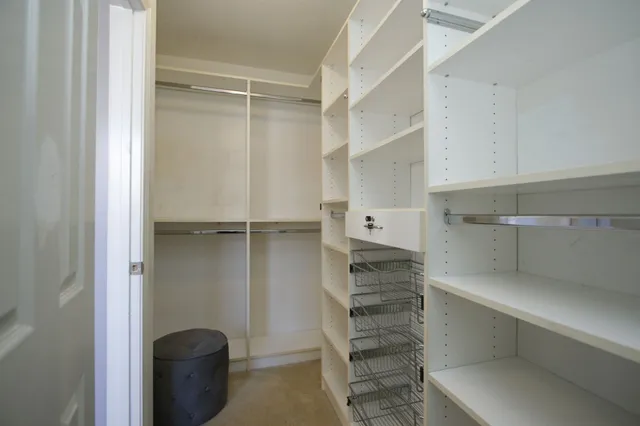 a view of walk in closet with empty racks