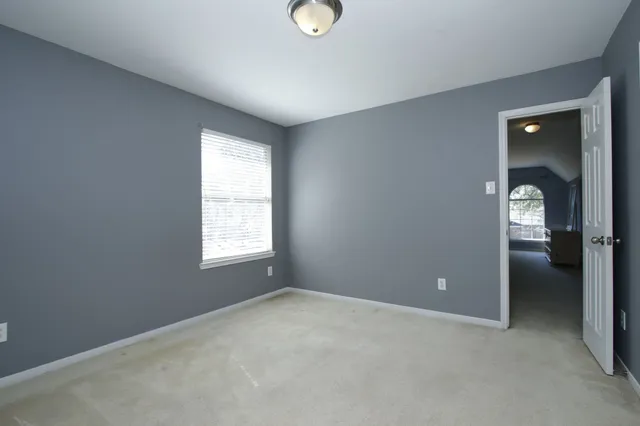 an empty room with windows and closet