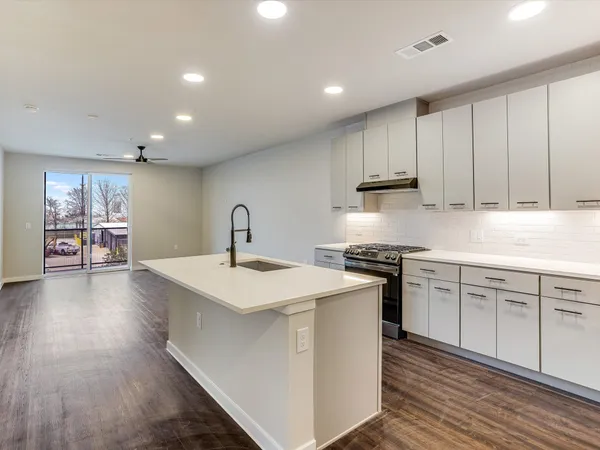 a kitchen with stainless steel appliances granite countertop a sink stove and cabinets