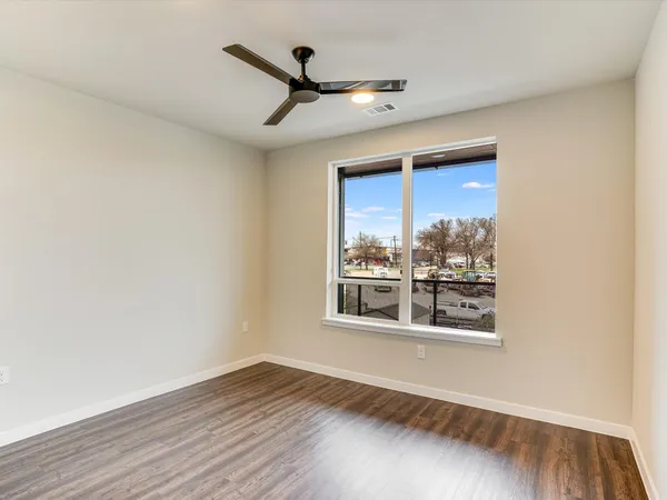 a view of a big room with wooden floor and a window