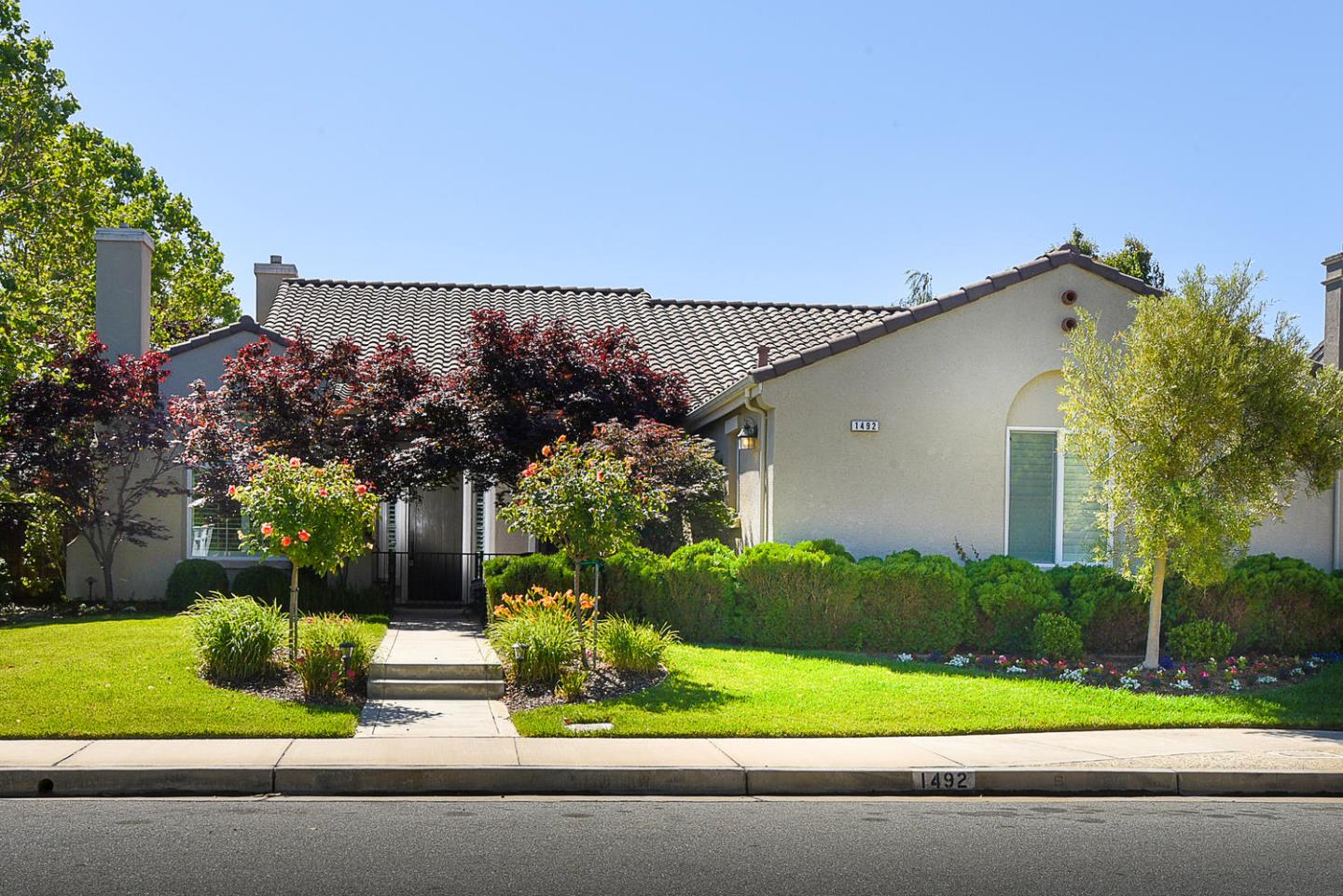 a front view of a house with a garden and plants