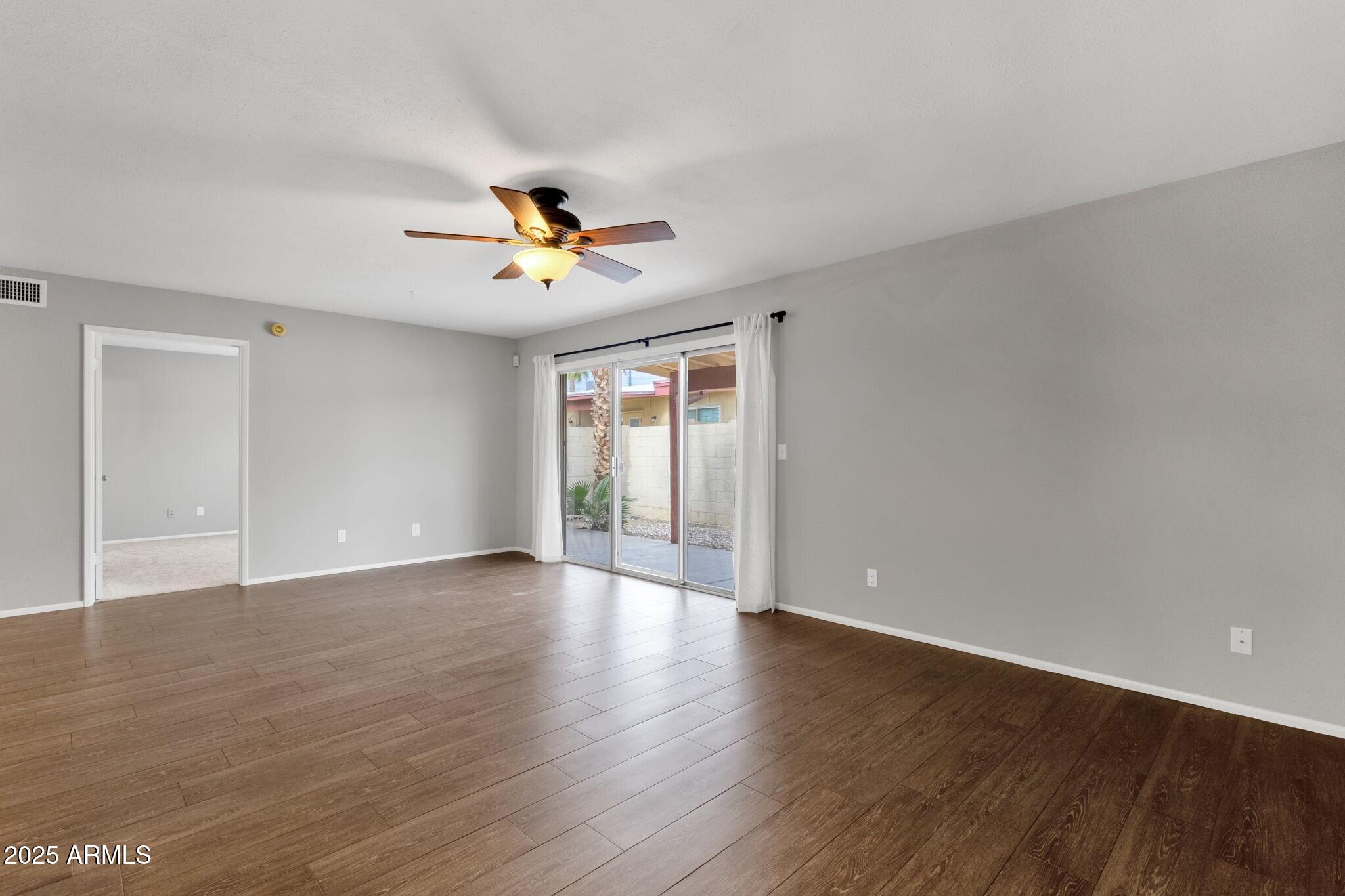 2530 East Wagoner Road Phoenix, AZ 85032 - Photo 10 of 35 a view of an empty room with window and wooden floor