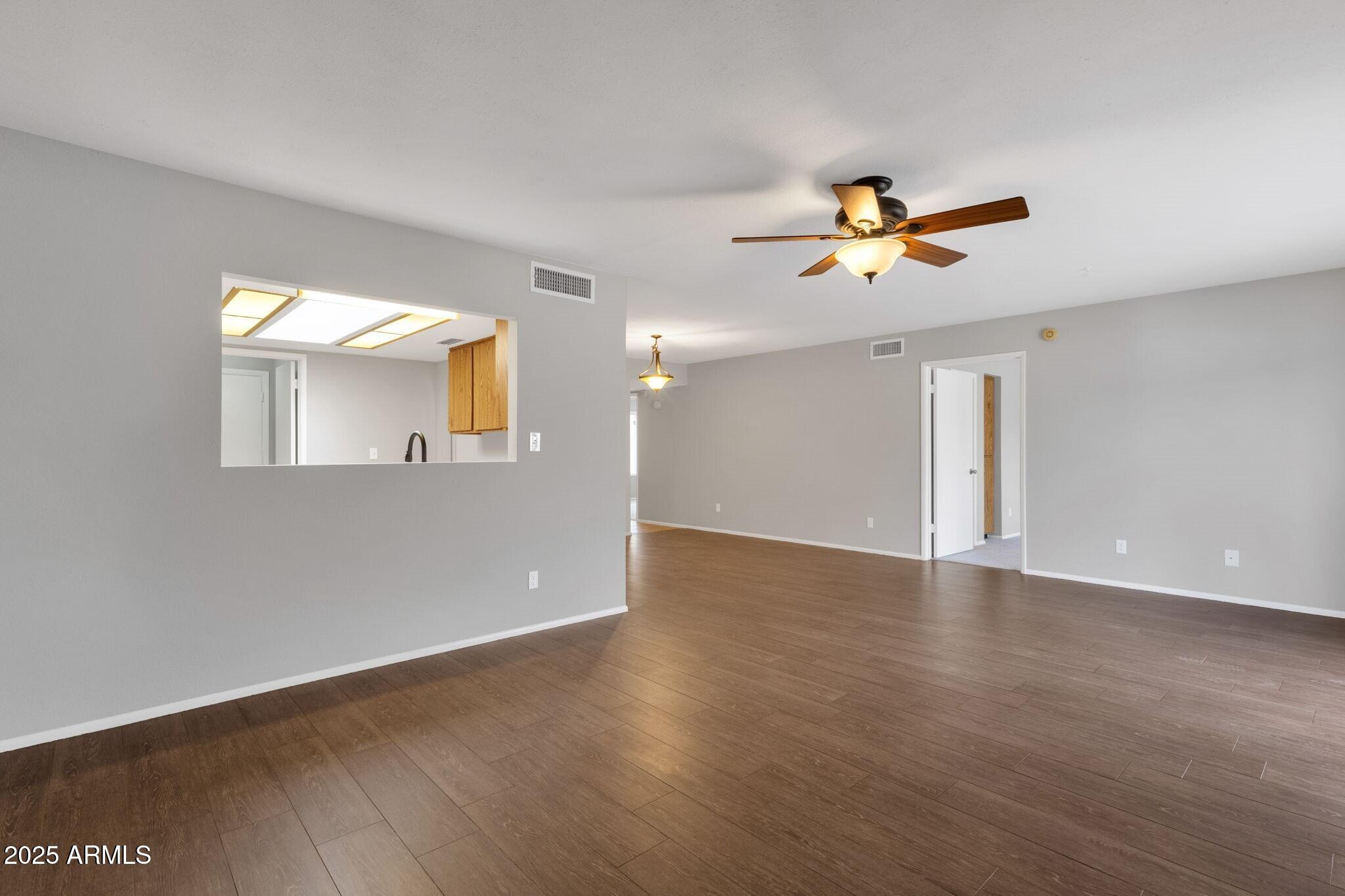 2530 East Wagoner Road Phoenix, AZ 85032 - Photo 11 of 35 a view of a big room with wooden floor and a ceiling fan