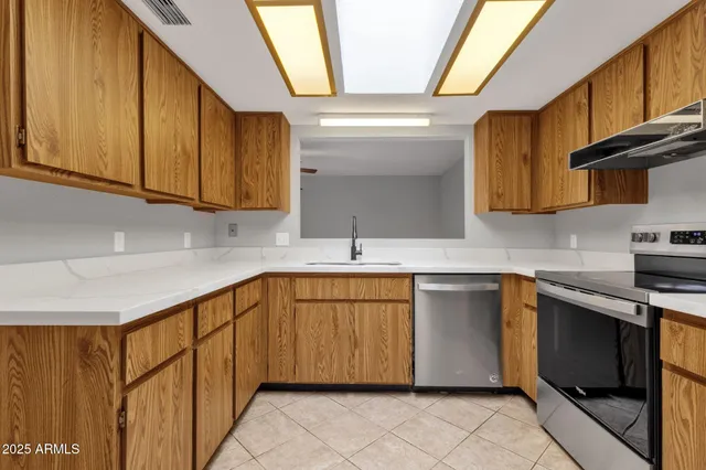 a kitchen with stainless steel appliances granite countertop a sink and a stove