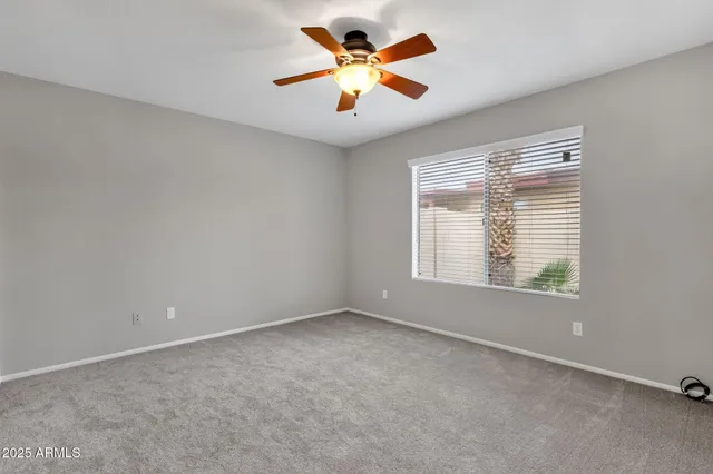an empty room with closet and a chandelier fan