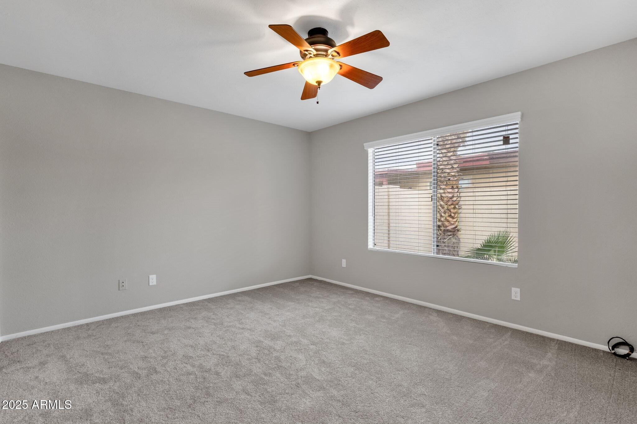2530 East Wagoner Road Phoenix, AZ 85032 - Photo 18 of 35 a view of an empty room with window and a chandelier fan