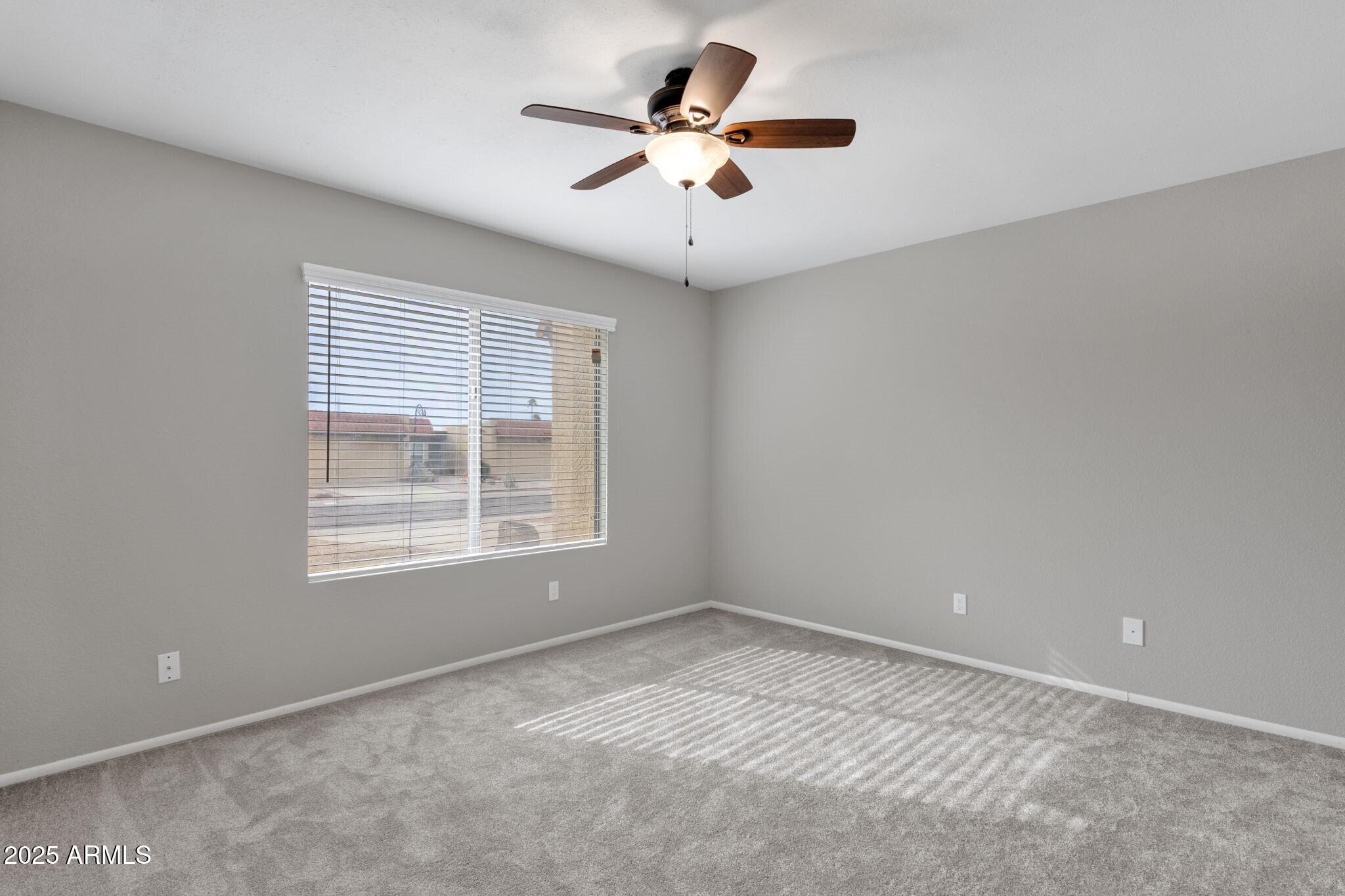 2530 East Wagoner Road Phoenix, AZ 85032 - Photo 23 of 35 an empty room with a window and a ceiling fan
