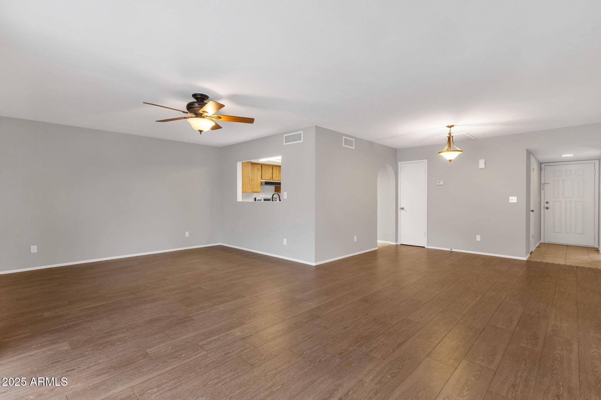 2530 East Wagoner Road Phoenix, AZ 85032 - Photo 7 of 35 a view of an empty room with wooden floor and a window