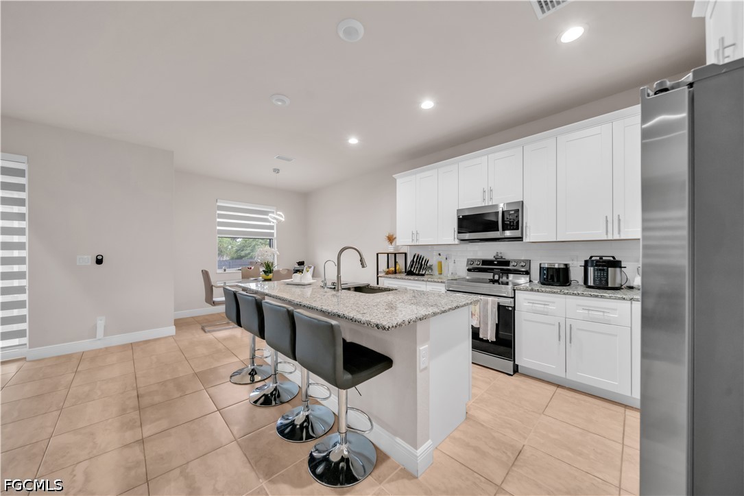 384 Neighborly Road LaBelle, FL 33935 - Photo 16 of 45 a open kitchen with stainless steel appliances granite countertop a sink and cabinets