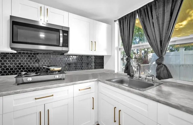 a kitchen with a sink a microwave a stove and cabinets