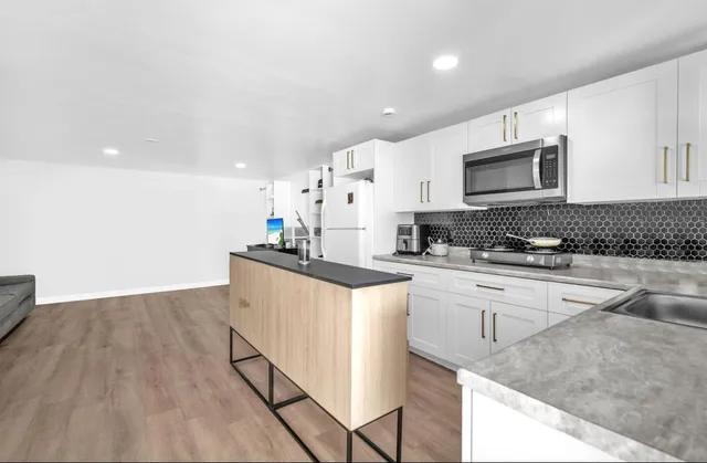a kitchen with stainless steel appliances granite countertop a stove a sink and a microwave