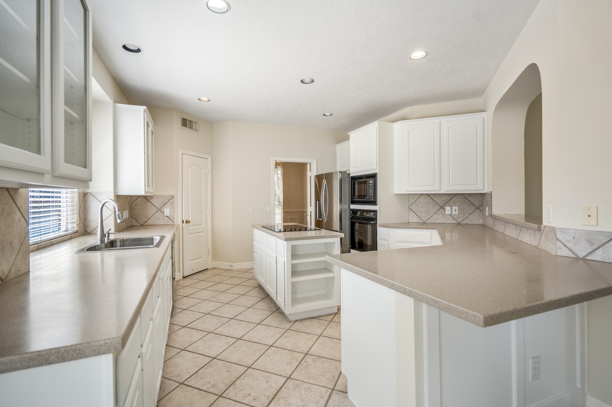 1322 Cardigan Bay Circle Spring, TX 77379 - Photo 16 of 50 The kitchen features crisp white raised-panel cabinets paired with a smooth, neutral-Corian countertop that has a subtle, clean edge.