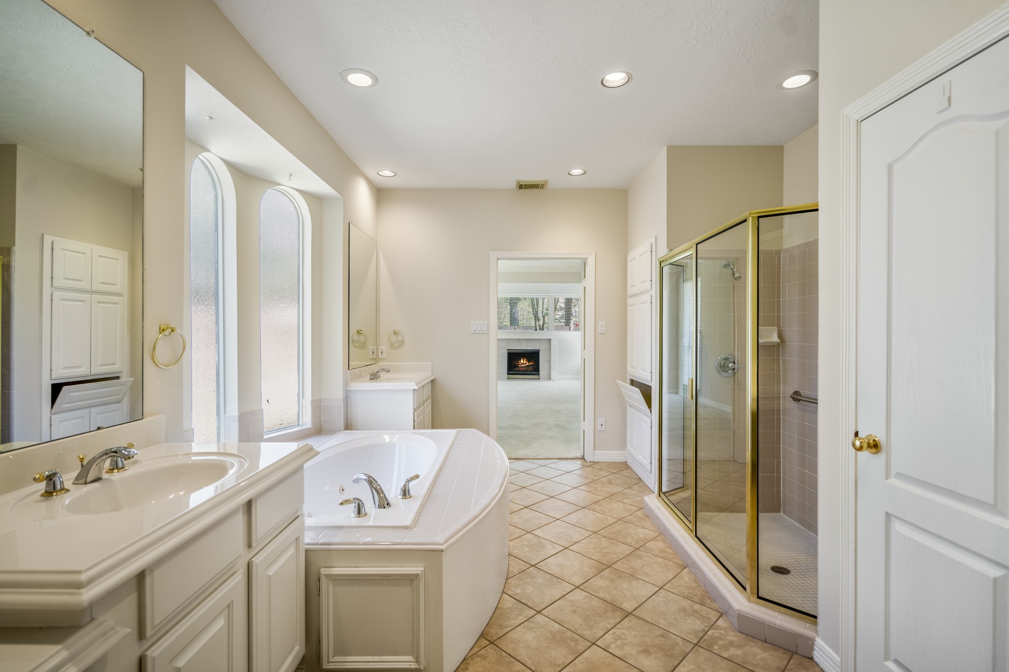 1322 Cardigan Bay Circle Spring, TX 77379 - Photo 25 of 50 The en-suite bathroom provides separate vanity stations on either side of the tub, with ample storage cabinets, and large wall-mounted mirror, tiled flooring, a whirlpool tub and glass enclosed shower.