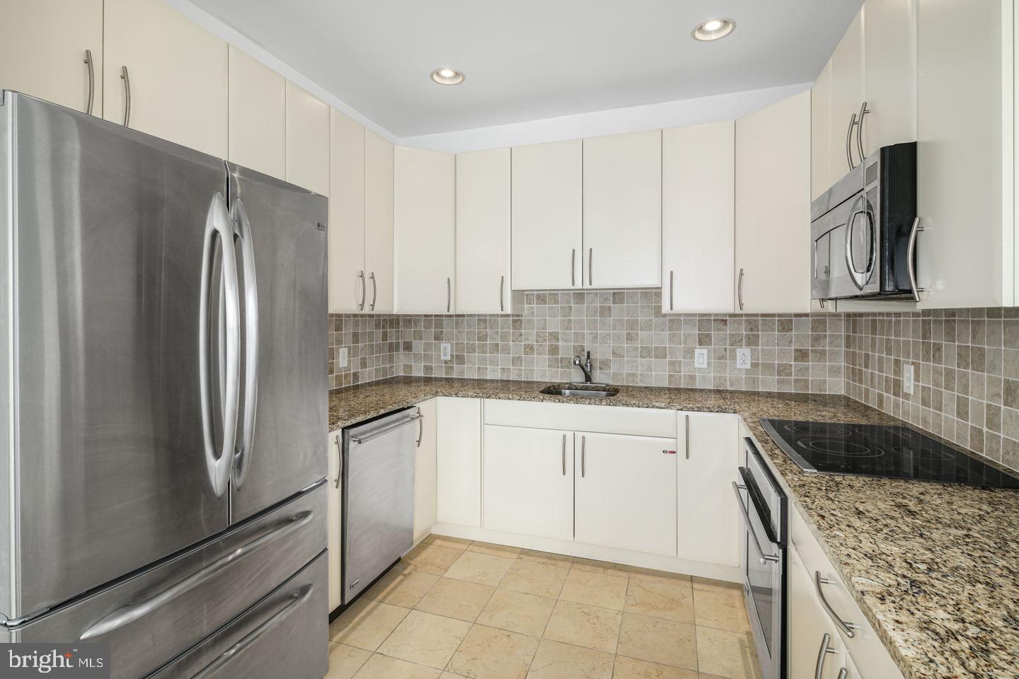 901 North Penn Street, Unit R1802 Philadelphia, PA 19123 - Photo 9 of 32 a kitchen with stainless steel appliances granite countertop a refrigerator sink and stove