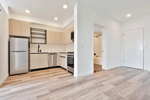 a kitchen with a refrigerator and white cabinets