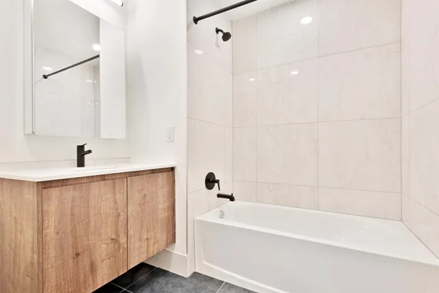 a bathroom with a bathtub a shower and a sink