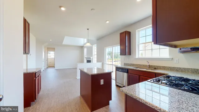 a kitchen with stainless steel appliances kitchen island granite countertop a sink stove and cabinets