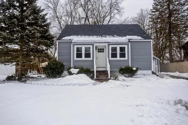 a front view of a house with a yard covered with snow