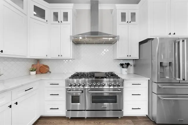 a kitchen with stainless steel appliances white cabinets and a stove