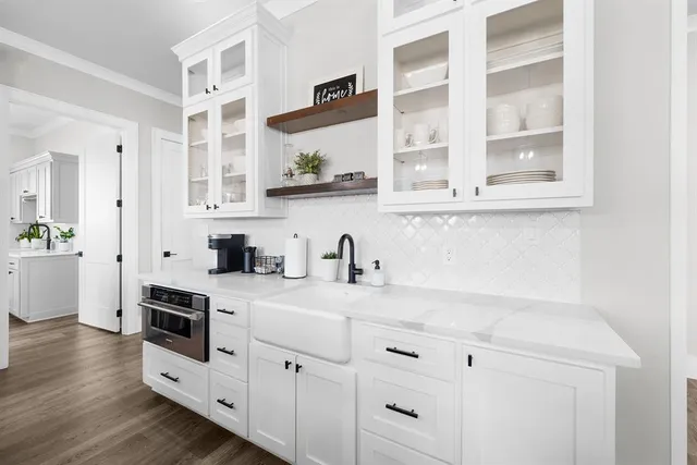 a kitchen with granite countertop white cabinets and white appliances