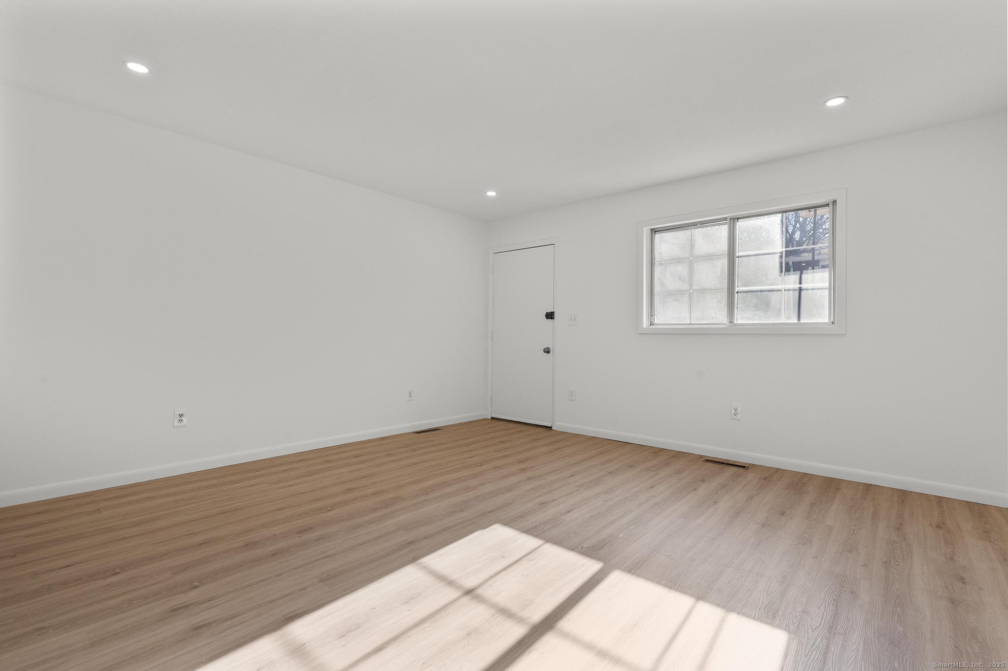 65 Patricia Road, Unit N Bridgeport, CT 06606 - Photo 16 of 25 an empty room with wooden floor and windows