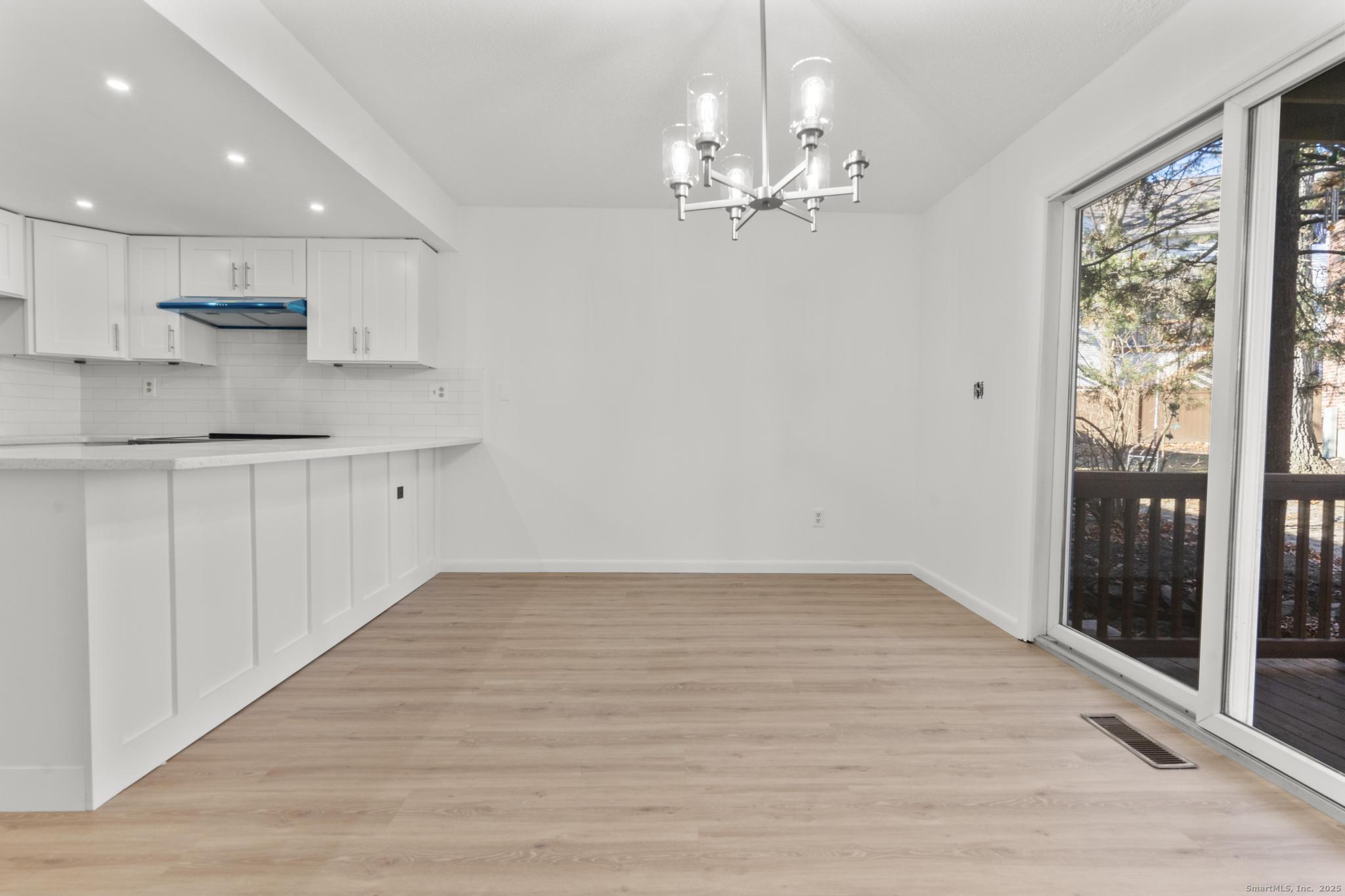65 Patricia Road, Unit N Bridgeport, CT 06606 - Photo 5 of 25 a view of granite countertop kitchen with a sink refrigerator and wooden floor