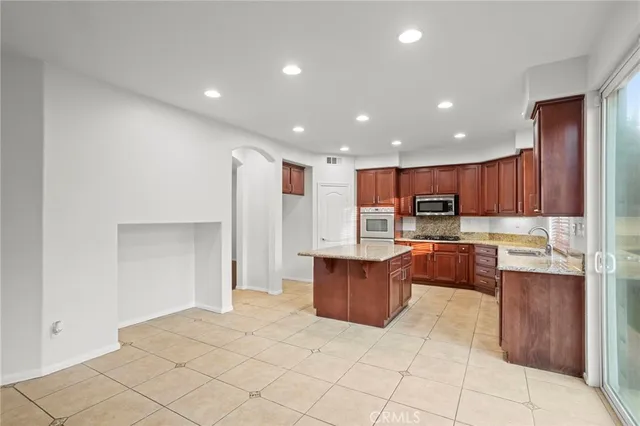 a kitchen with stainless steel appliances granite countertop a refrigerator a sink and a stove